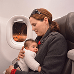 A baby being cuddled inside a plane
