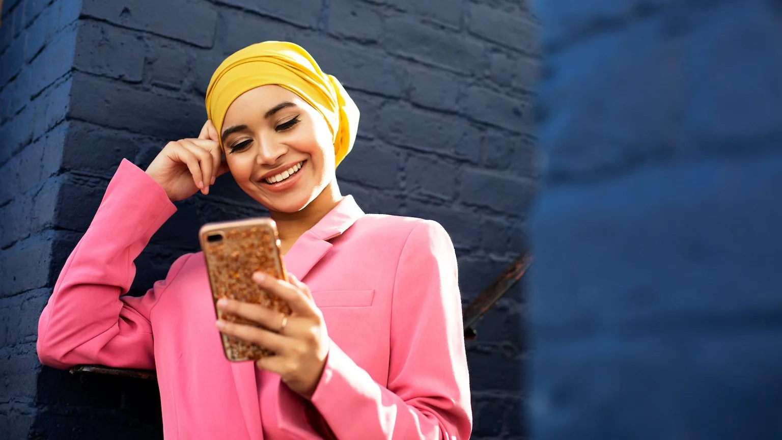Image: Getty Images Young lady checking phone and smiling.
