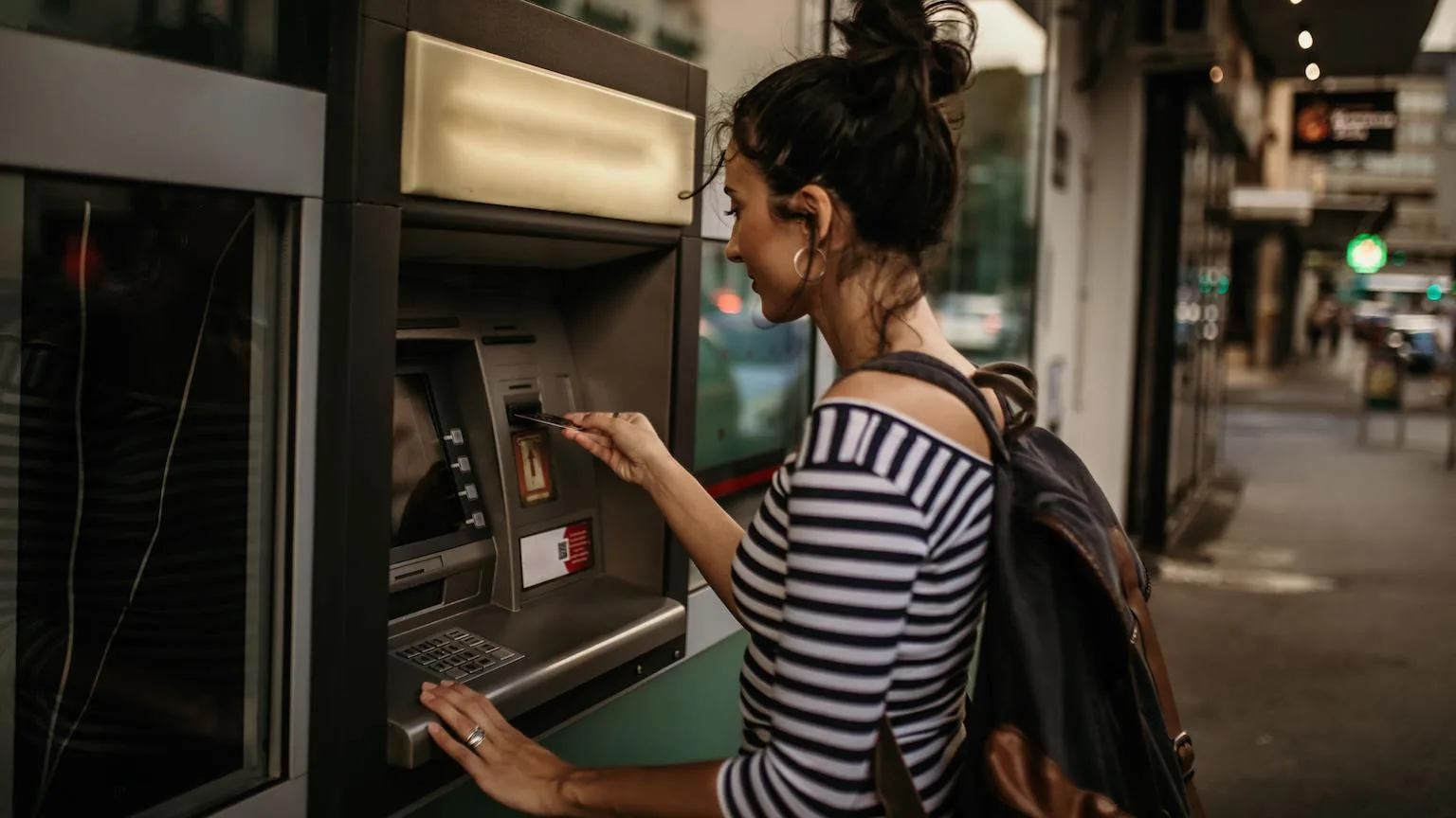 Image: Getty Images Lady using credit card to withdraw money from ATM.
