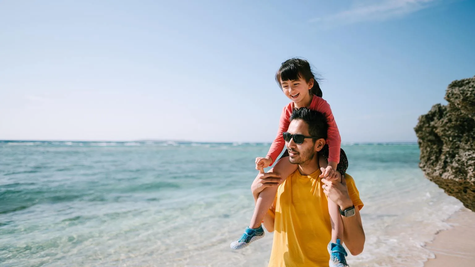 Image: Getty Images Father and daughter walking along the shoreline at the beach.