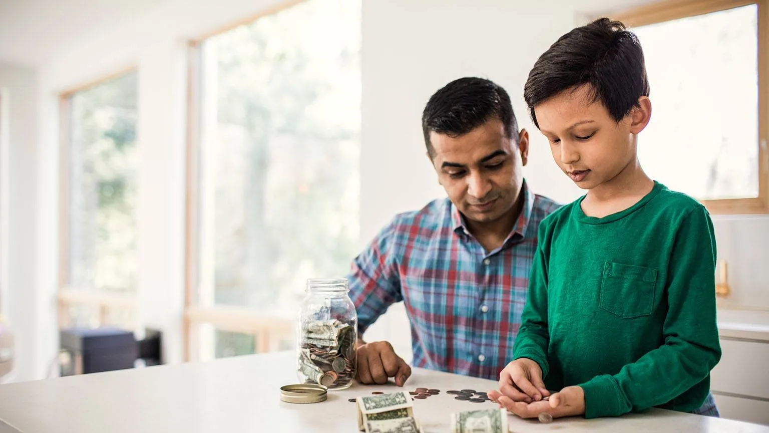 Image: Getty Images Father and son counting money