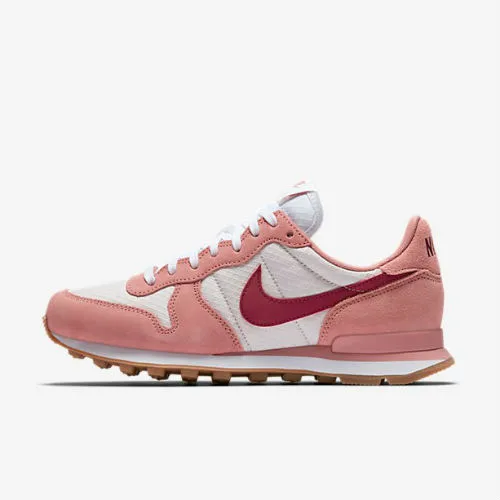 white nike shoes with pink logo