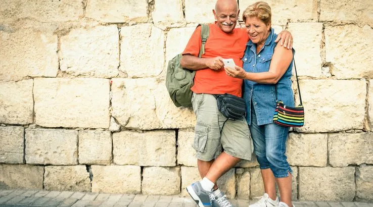 Relaxed seniors travelling and looking at smartphone