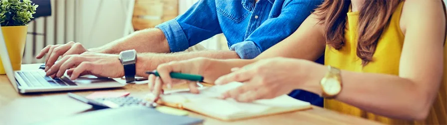 couple's hands with laptop and notepad