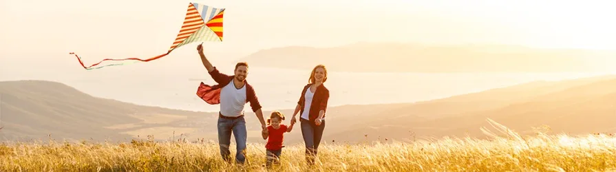 family flying kite during golden hour