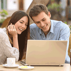 couple smiling at laptop