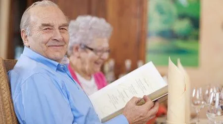 old couple smiling while checking menu