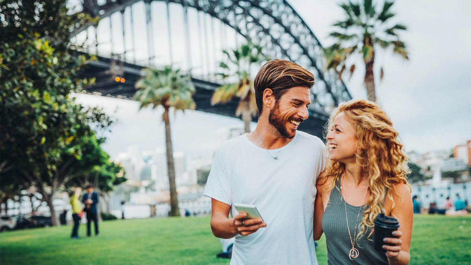 Image: Getty Images Smiling couple in front of the Sydney Harbour Bridge
