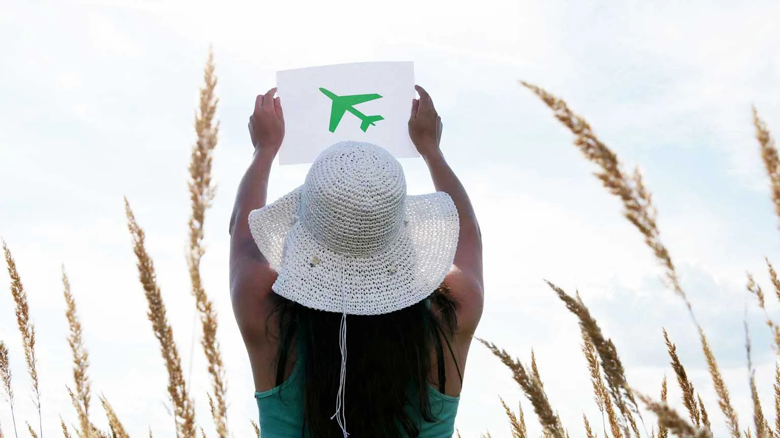 Image: Getty Images Woman holding a picture of a green airplane.