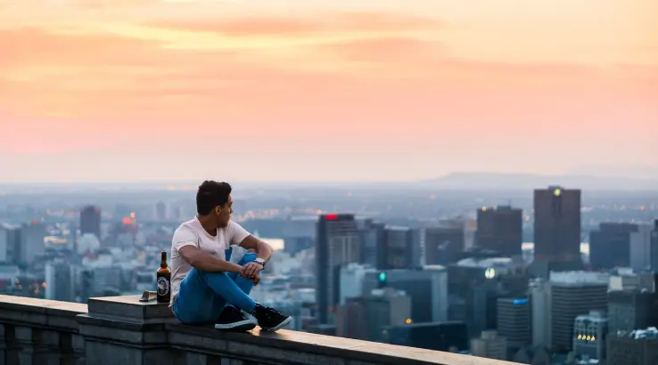 Image: Unsplash Man sitting on ledge staring at the city.