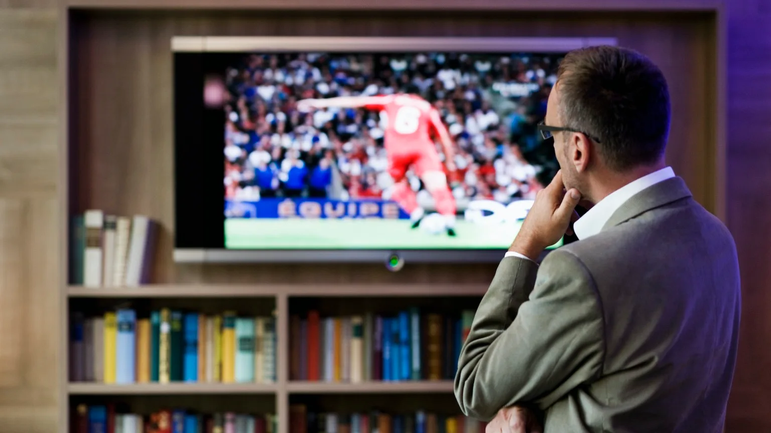 Image: Getty Images Man watching soccer on flat panel television