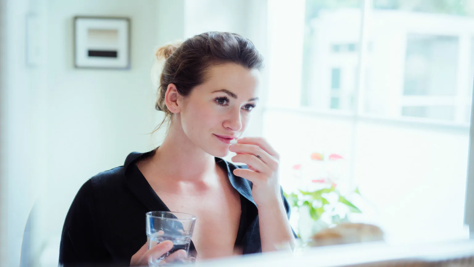 Image: Getty Images Woman taking vitamins