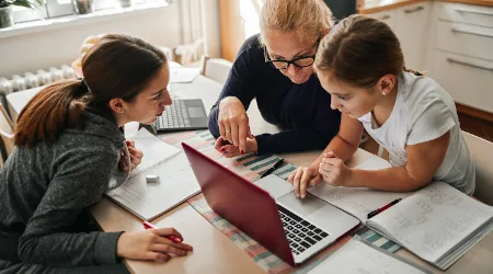 Homeschooling - Mother Helping To Her Daughters To Finish School Homework During Coronavirus Quarantine Homeschooling - Mother Helping To Her Daughters To Finish School Homework During Coronavirus Quarantine