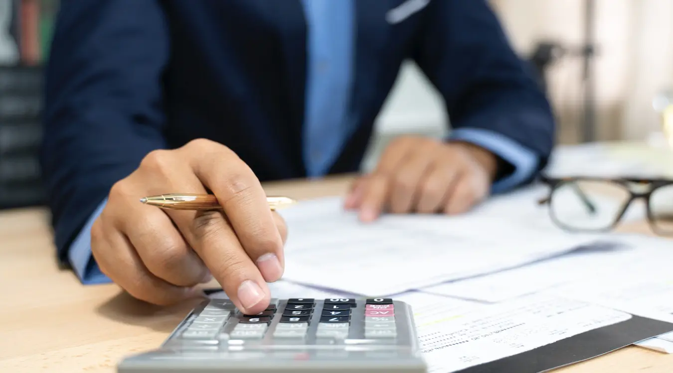 Hands of bank officer calculating loans Hands of bank officer calculating loans