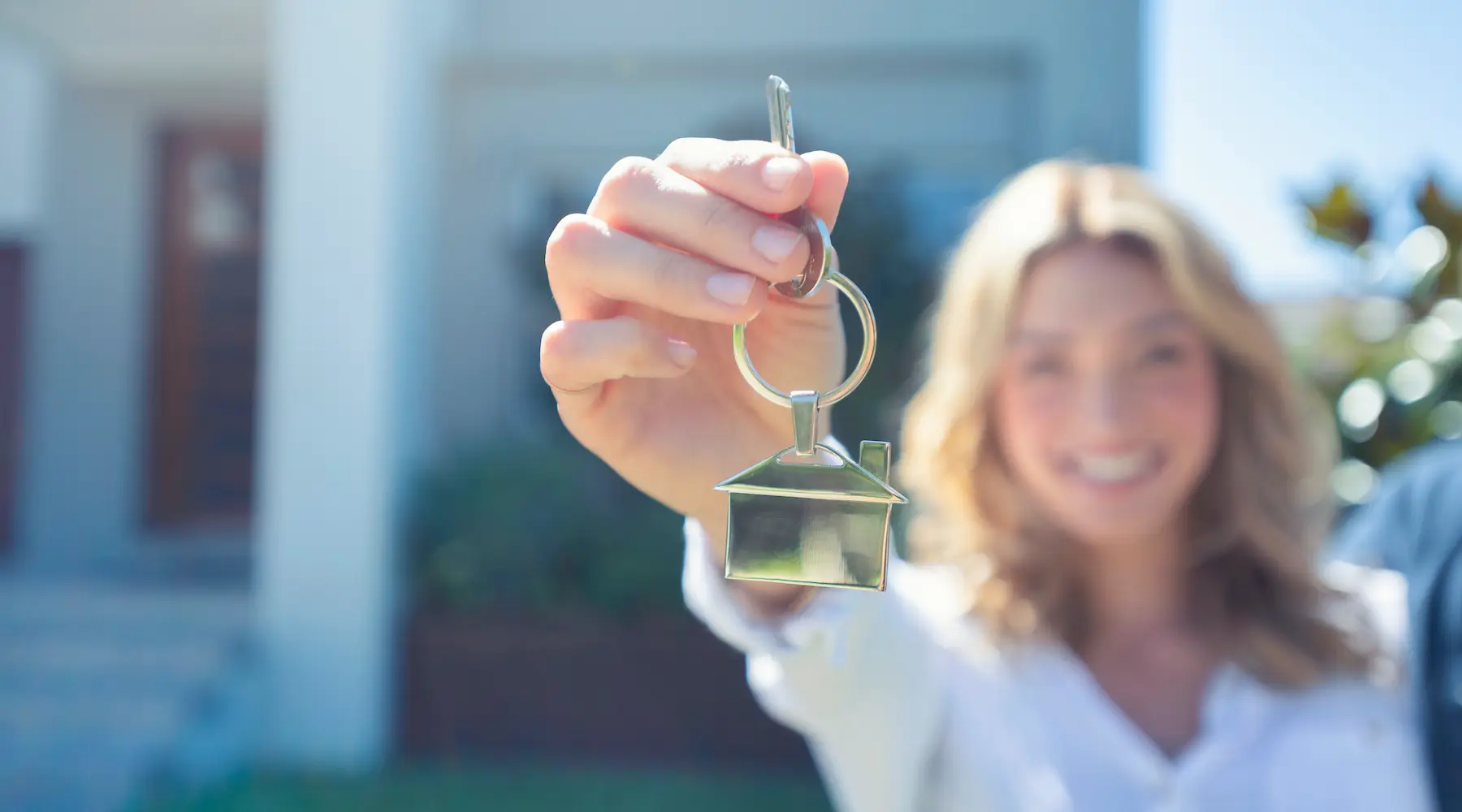 Young woman holding the key to her new house. Young woman holding the key to her new house.