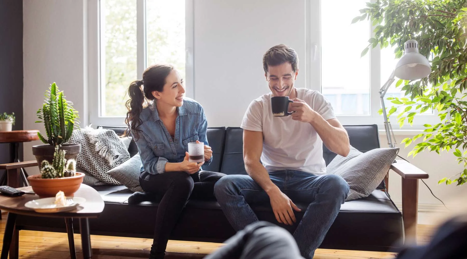 Couple having coffee together in living room Couple having coffee together in living room