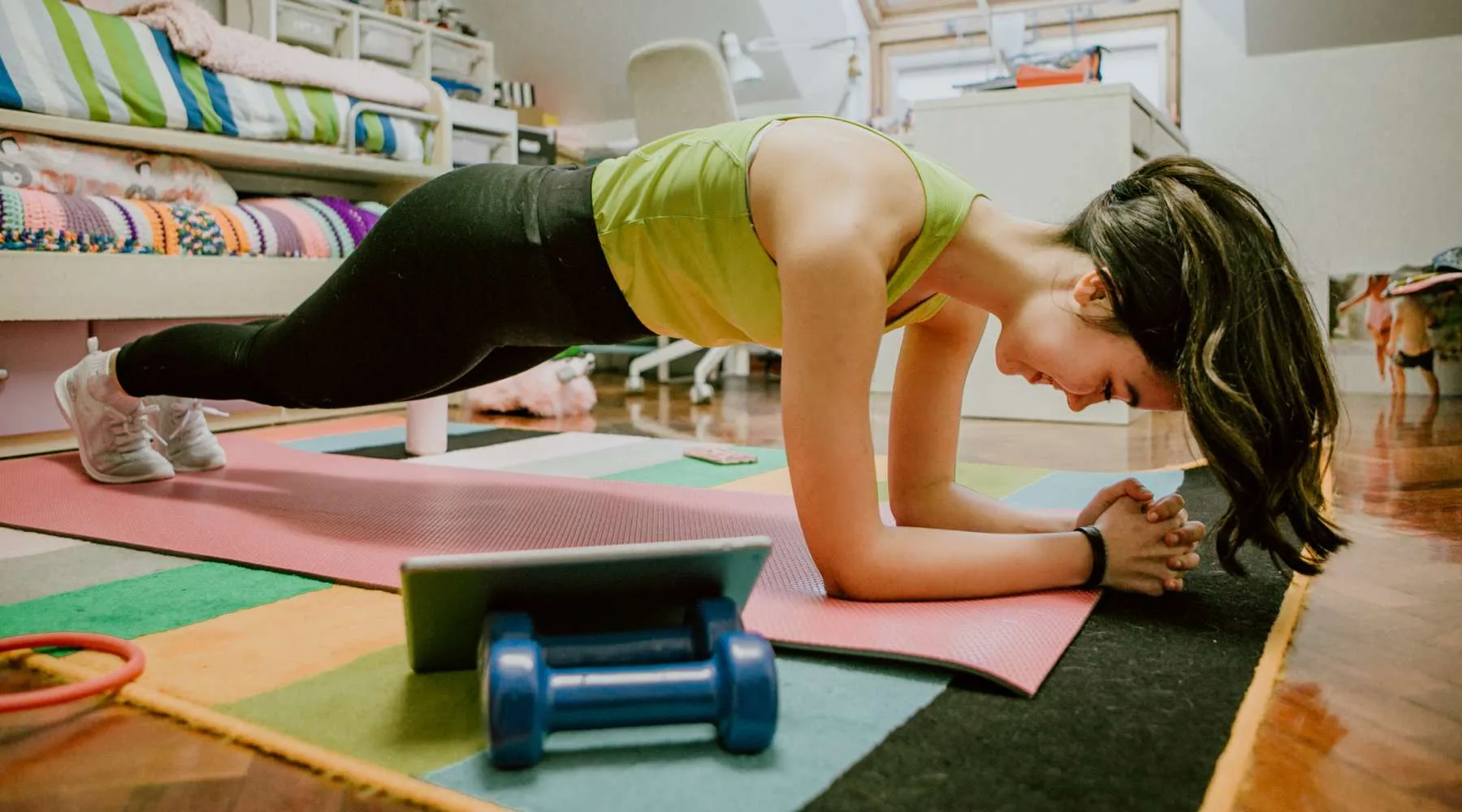 Woman doing exercises through online videos at home Woman doing exercises through online videos at home