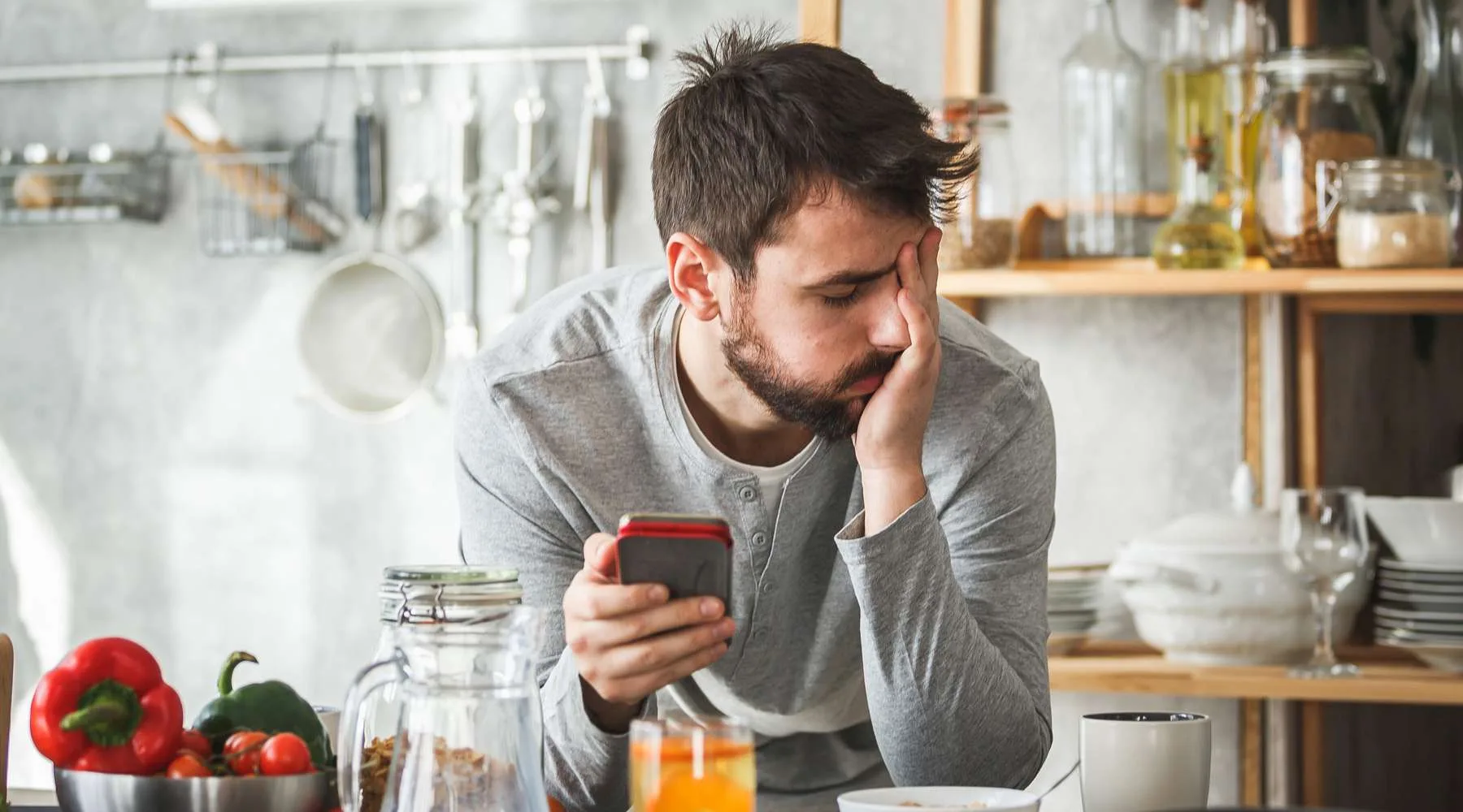Sad man using smart phone during breakfast at home Sad man using smart phone during breakfast at home