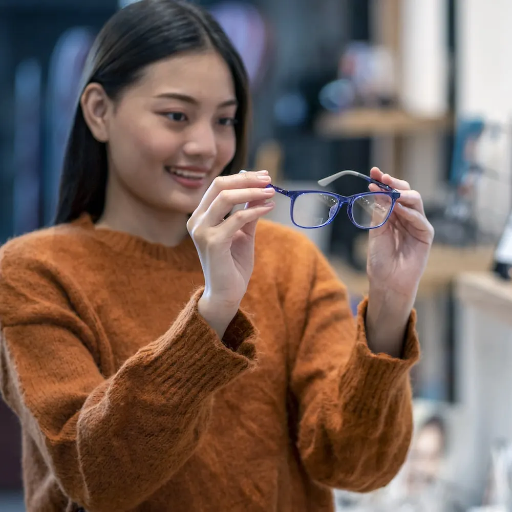 Woman holding prescription glasses