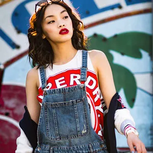 Asian brunette woman walking with sunglasses on the top of her head and red lips