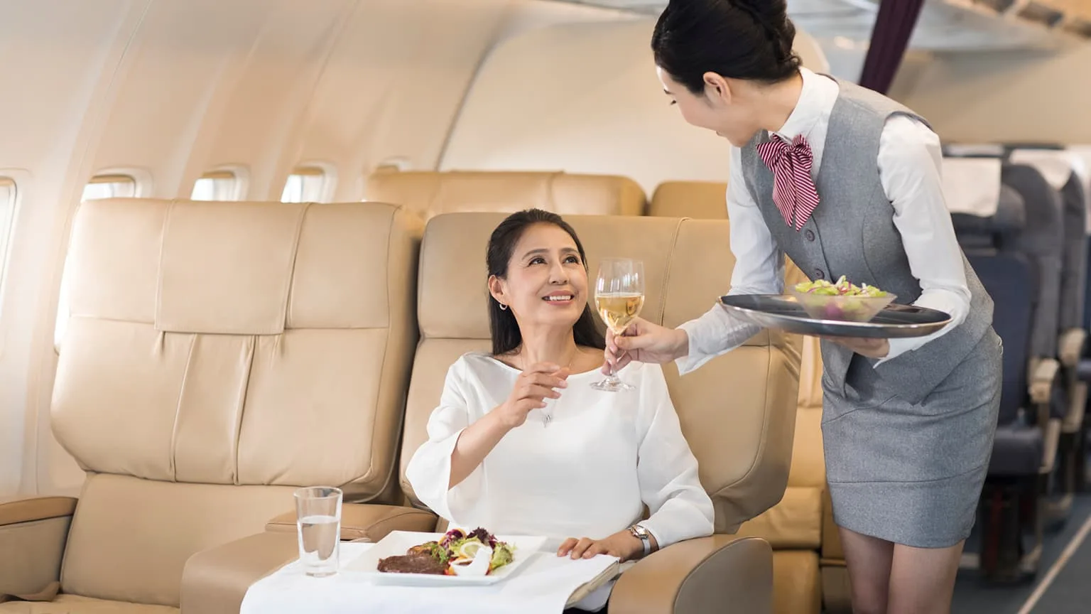Image: Getty Images Airline stewardess serving food to passenger