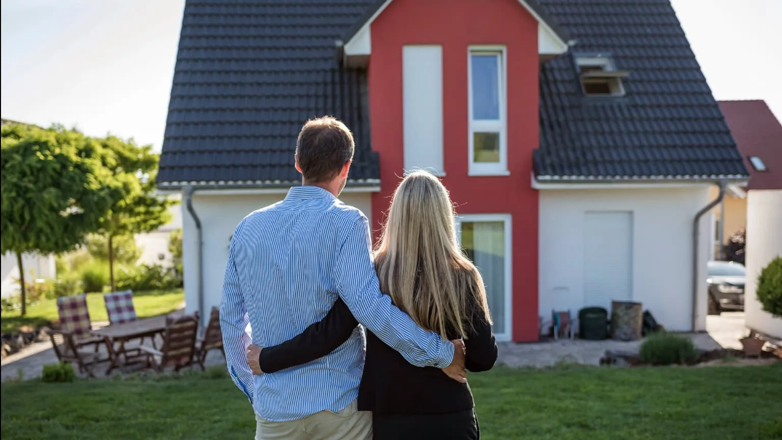 Image: Supplied A couple with hands around each other standing in front of a house