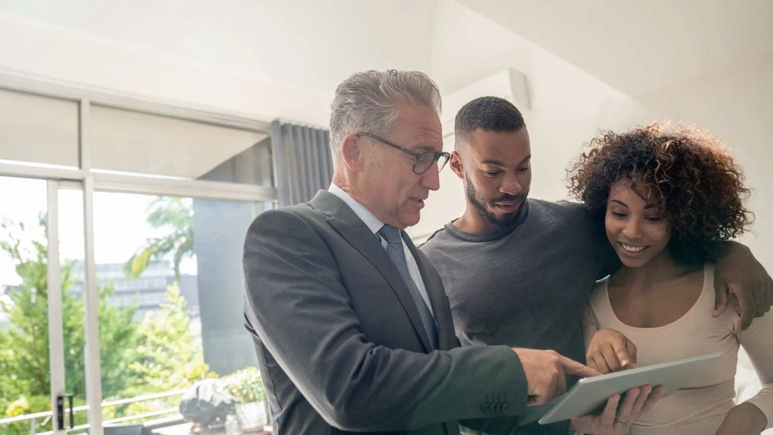 Image: Getty Images Young couple and a man in a suit looking at a document