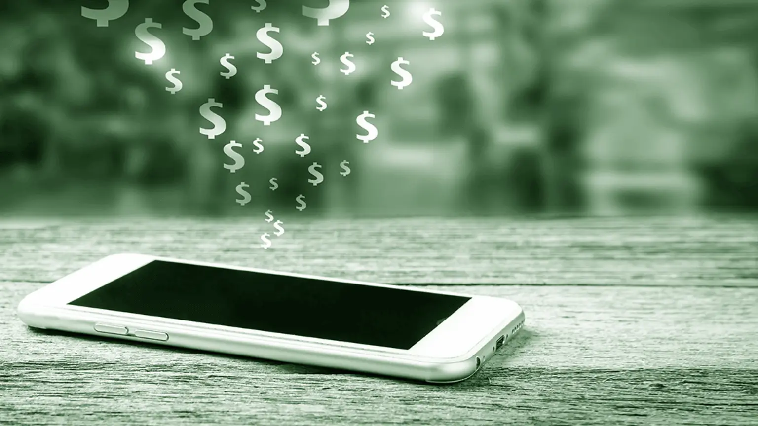 Image: Shutterstock Phone on a table with dollar signs floating above