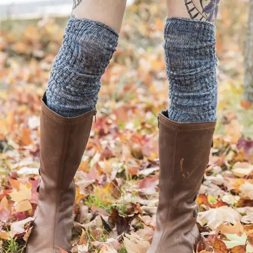 bottom leg of a women using high wool stockings and brown boots with spring leafs behind