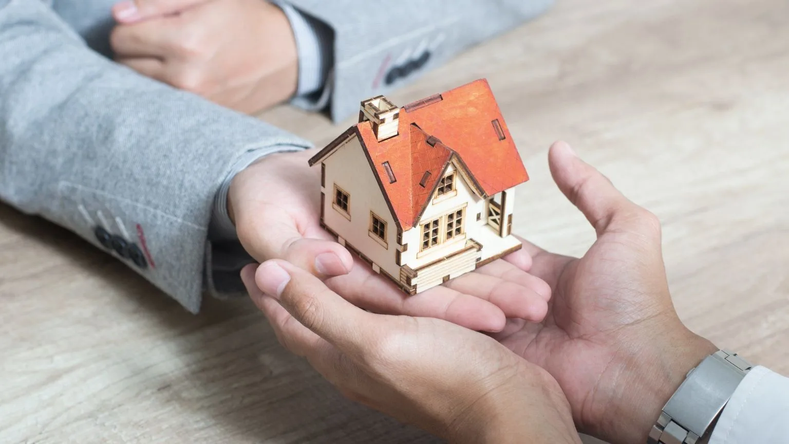 Image: Getty Images A hand giving a house model to another hand