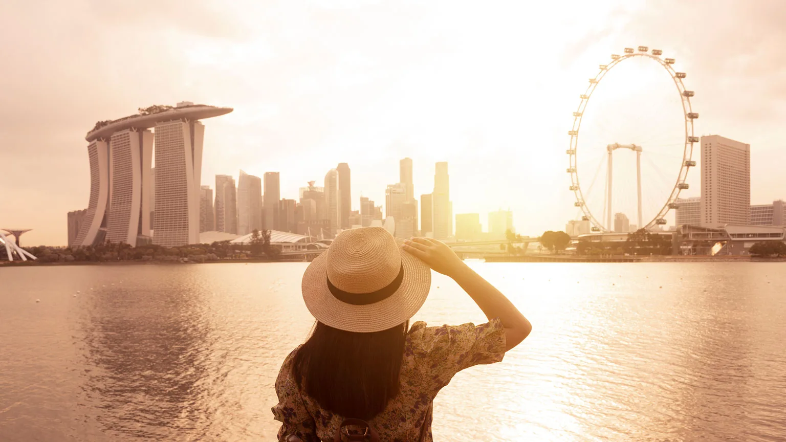 Image: Getty Images Back of woman tourist looking at downtown Singapore across the harbor