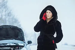 Woman on phone in front of car
