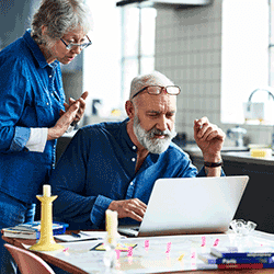 Image: Getty Images Senior man and woman looking at laptop