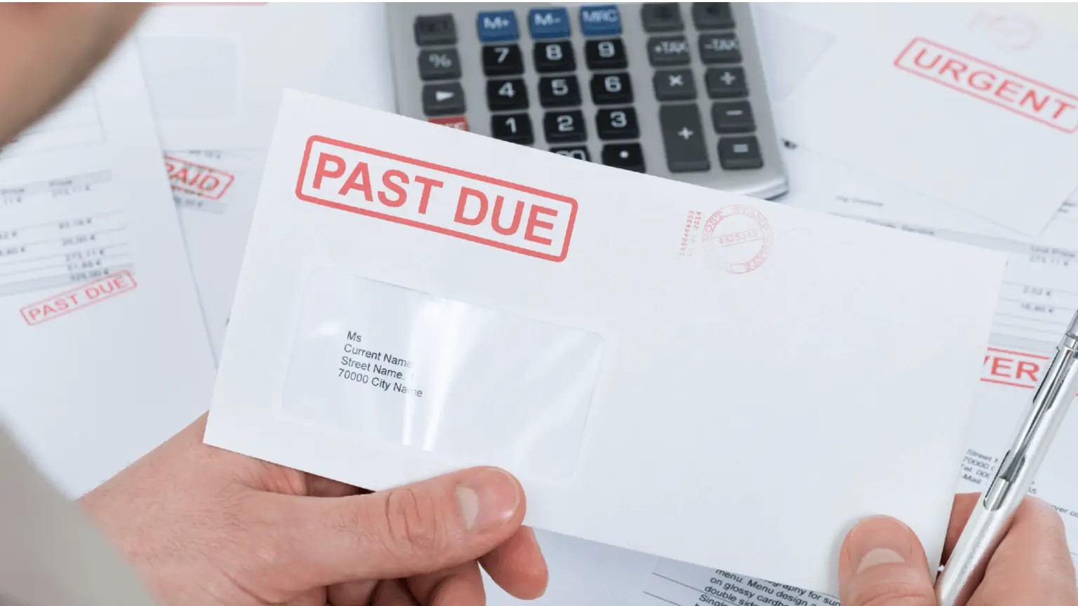 Image: Shutterstock Opening an a past due notice envelope with scissors.