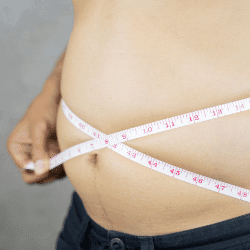 Image: Getty Images Man measures waist with measuring tape