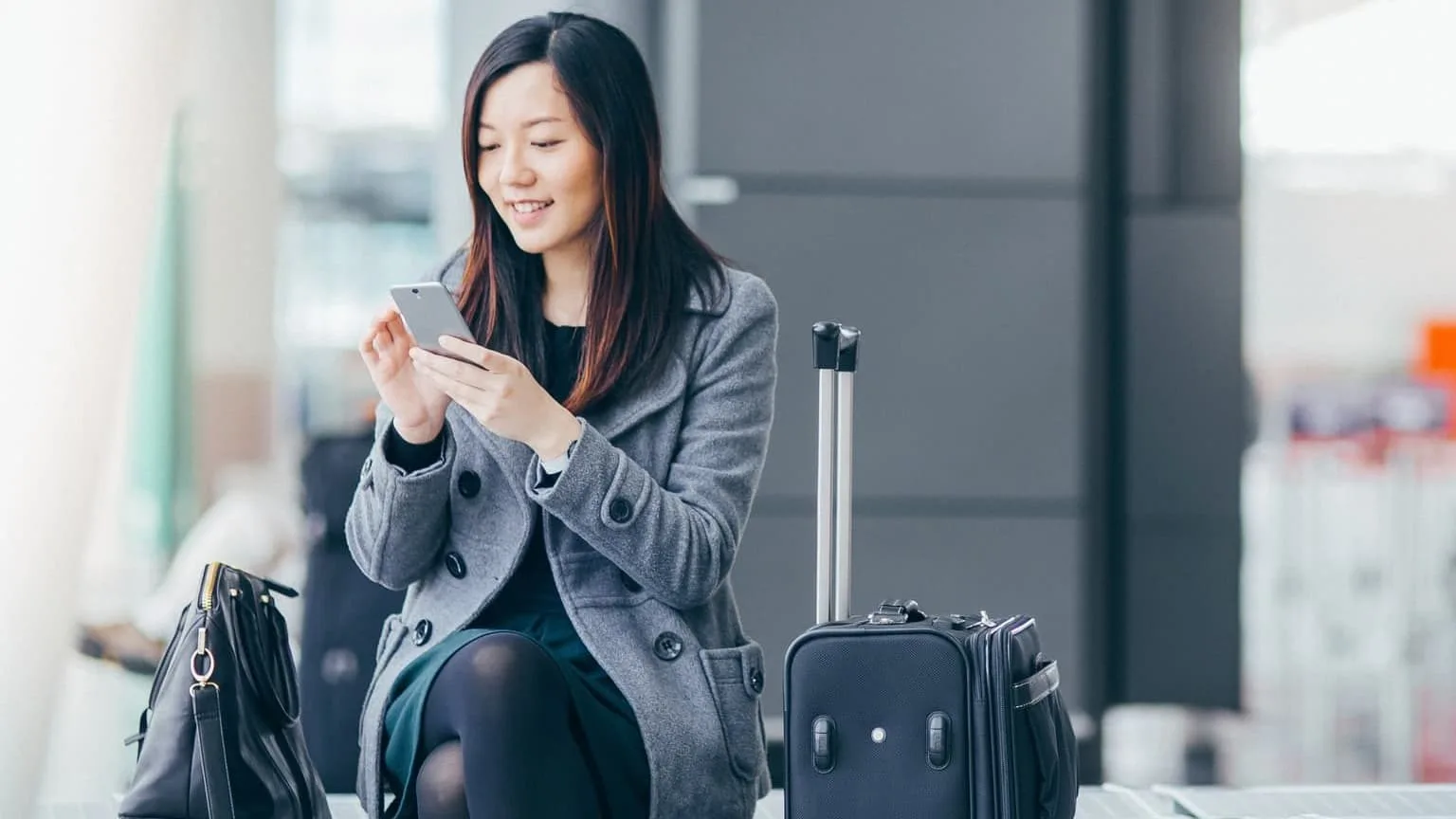 Image: Getty Images woman checking prepaid phone on airport