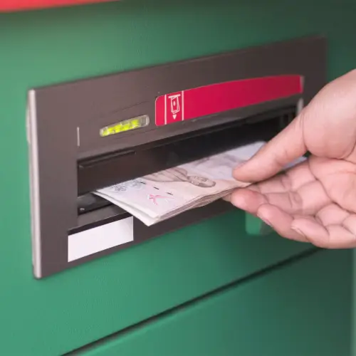 Hand removing money from ATM