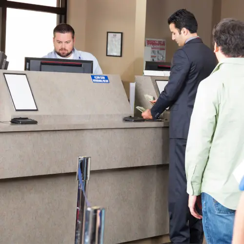Man counting money at bank teller