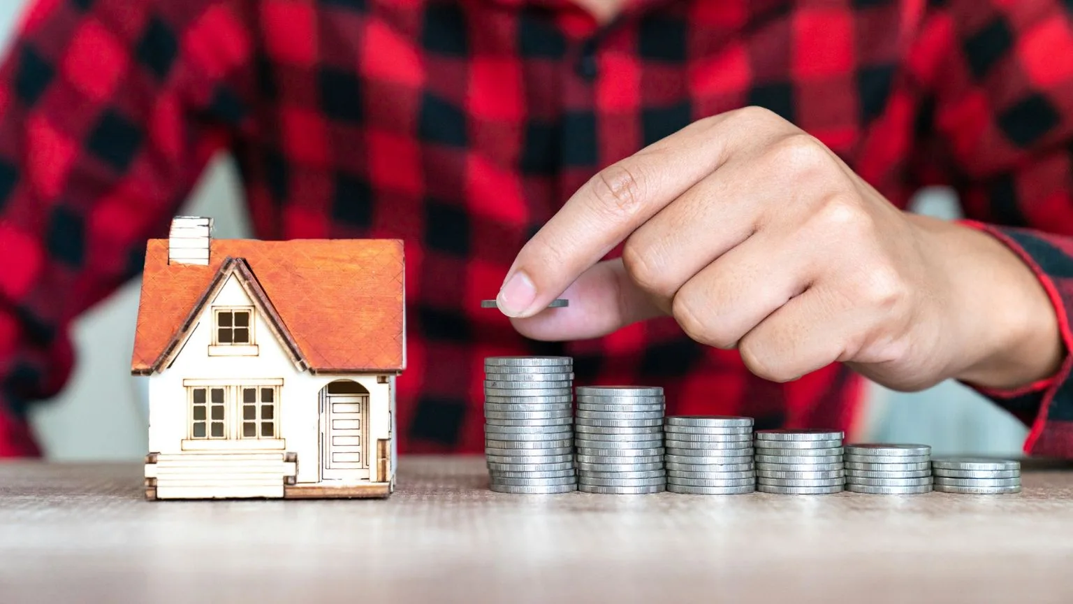 Image: Getty Images Model of house with coins on wooden table