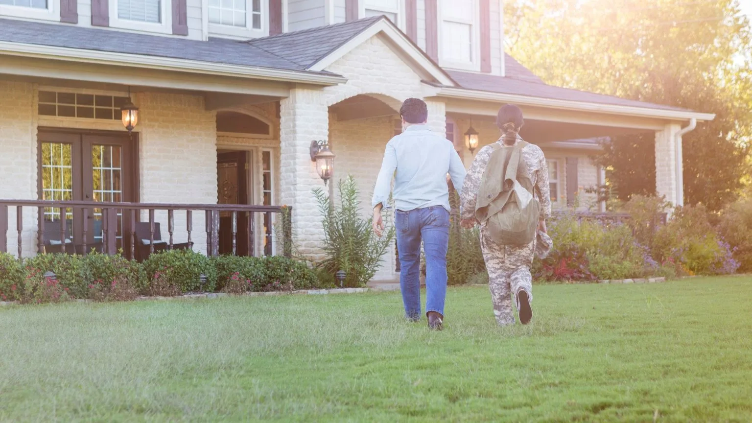 Image: Getty Images Rear view of husband and military wife entering home together
