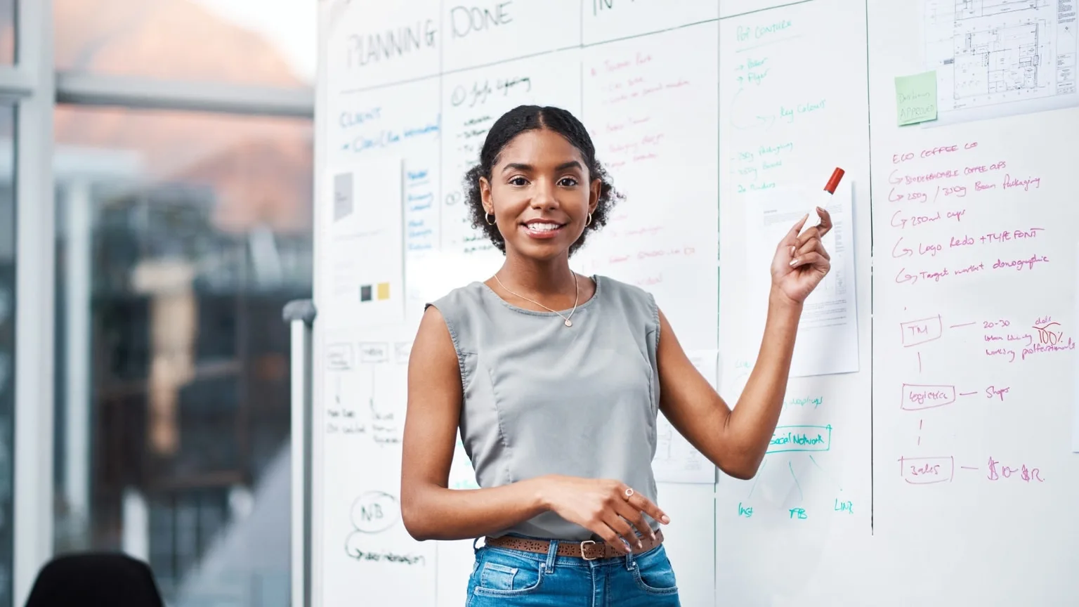 Image: Getty Images teacher with red whiteboard marker next to blackboard