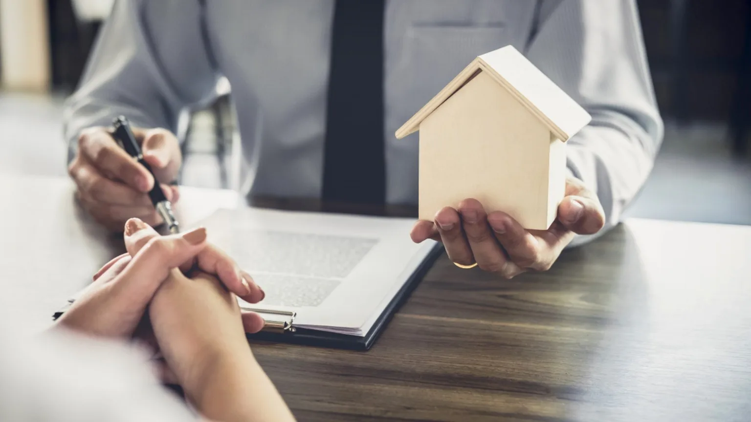 Image: Getty Images Midsection Of Agent Holding Model Home