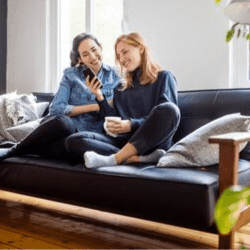 Image: Getty Images Friends checking mobile on sofa