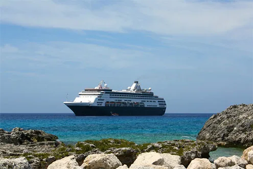 cruise ship off shore rocky beach