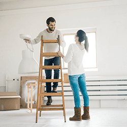 Image: Getty Images New homeowners installing a lamp in a house