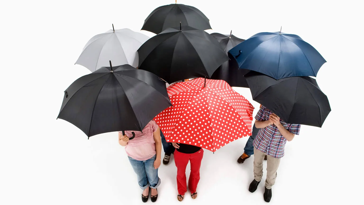 Image: Getty Images Group of men and women standing under umbrellas