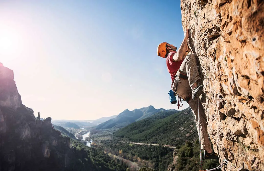 Image: Getty Images Rock climber climbing a mountain