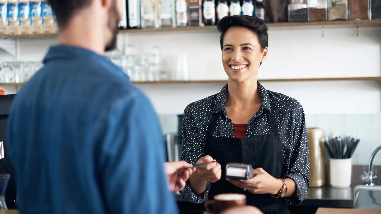 Image: Getty Images Saleswoman accepting a card payment from a customer at POS