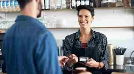 Saleswoman Accepting Card Payment At POS