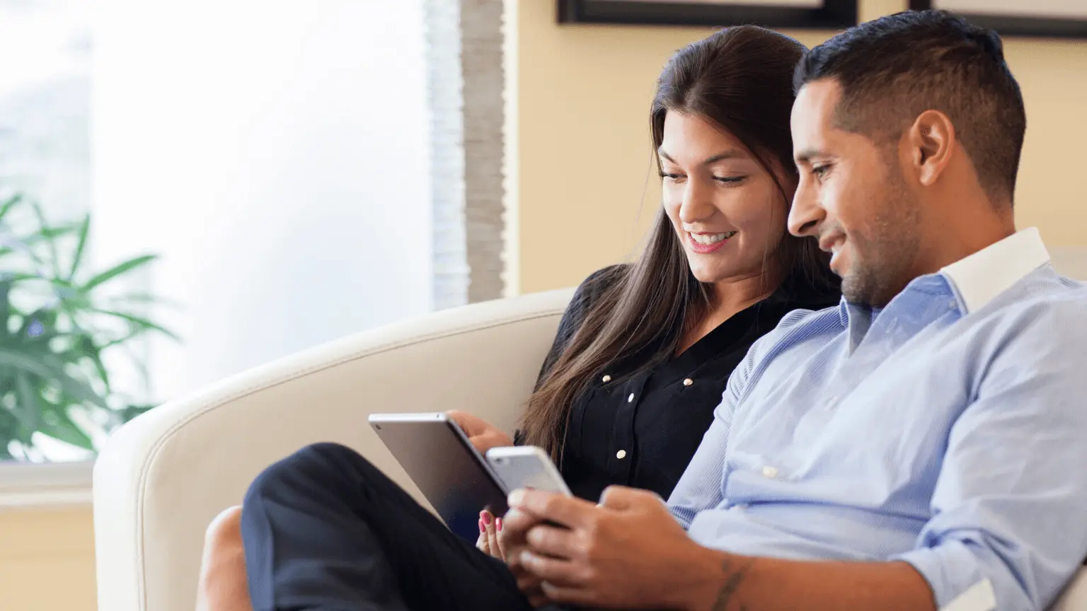 Image: Getty Images Couple looking at the phone sitting on the couch